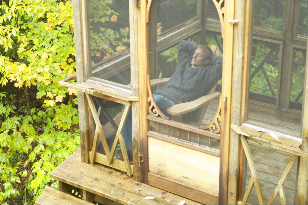 Guy relaxing inside screened-in porch