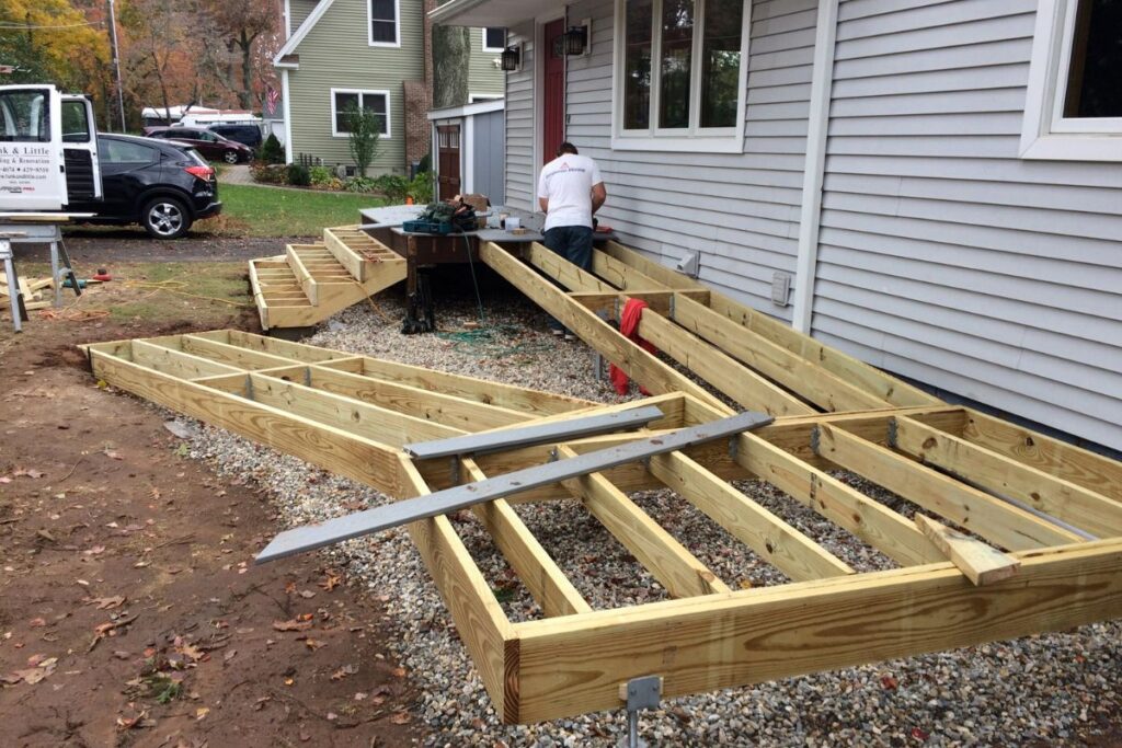 contractors installing wood frame for deck ramp