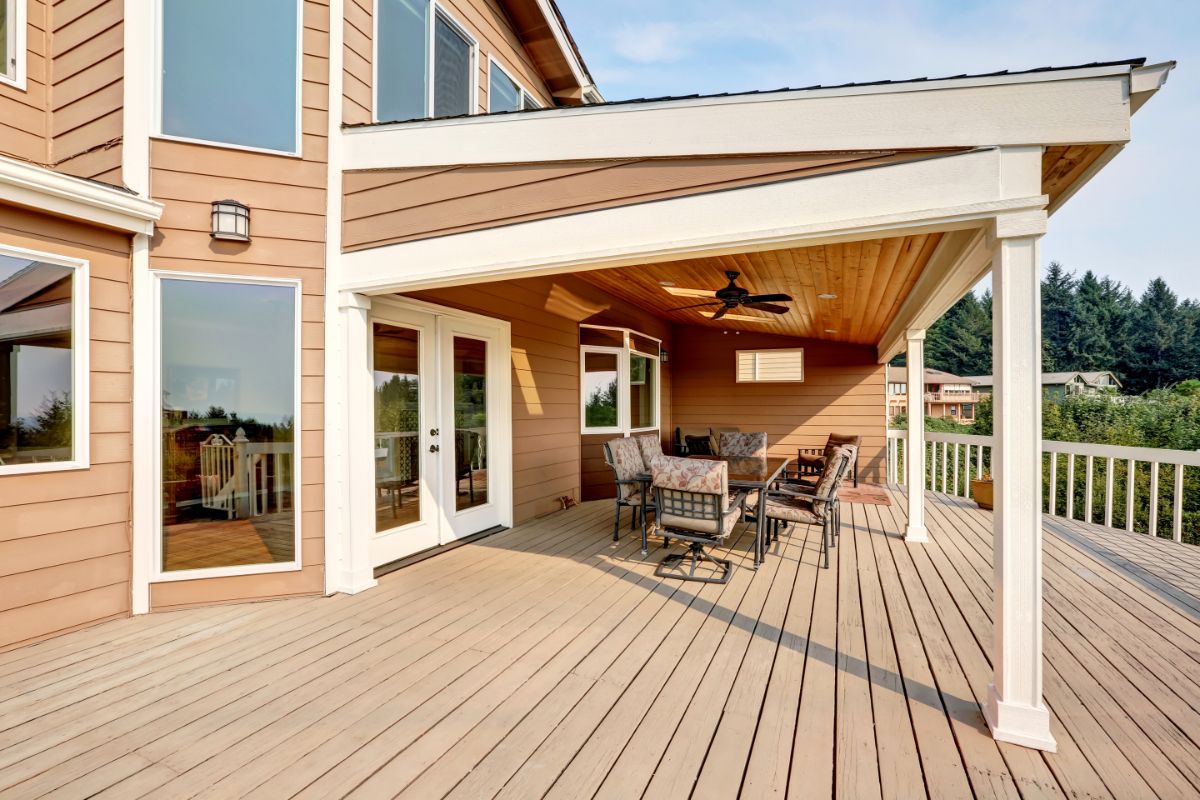 large wooden walkout deck with flat roof extension