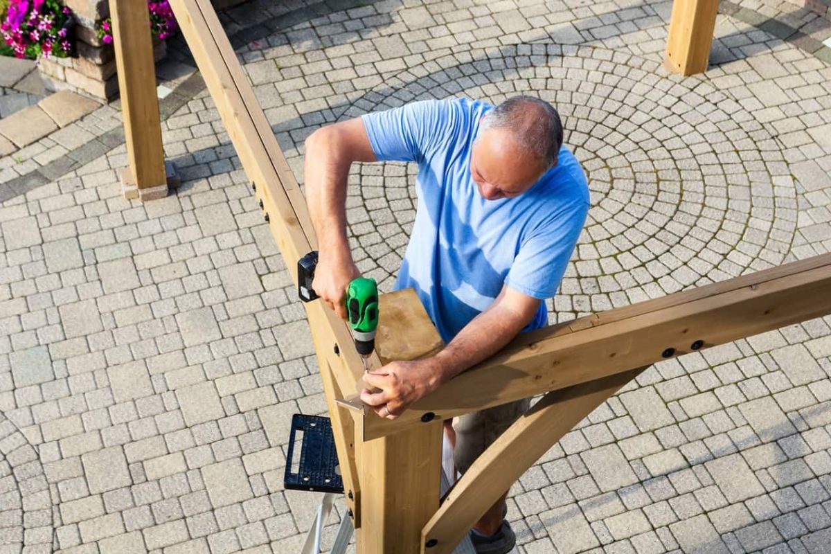 a man building a new pergola made of wood