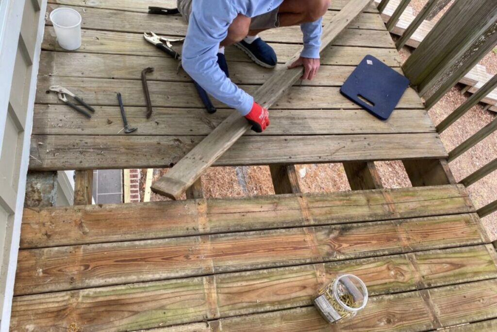 a contractors replacing the old wood deck on porch