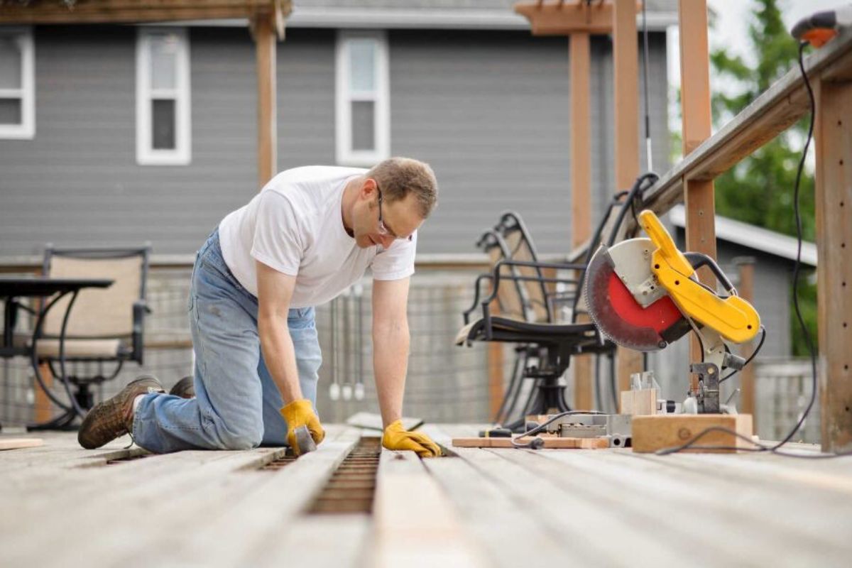 a man repairing wooden deck