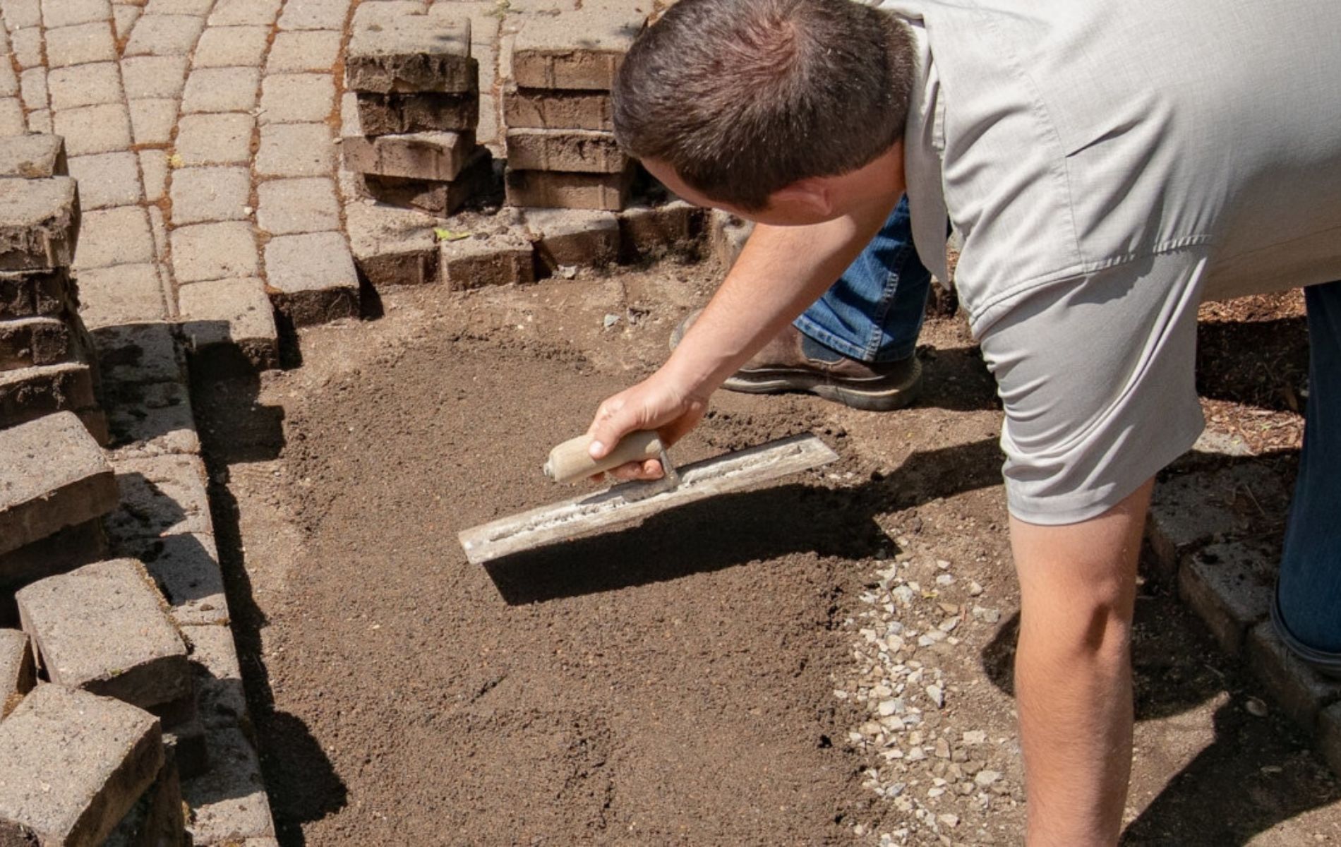 a man repairing stone pavers patio